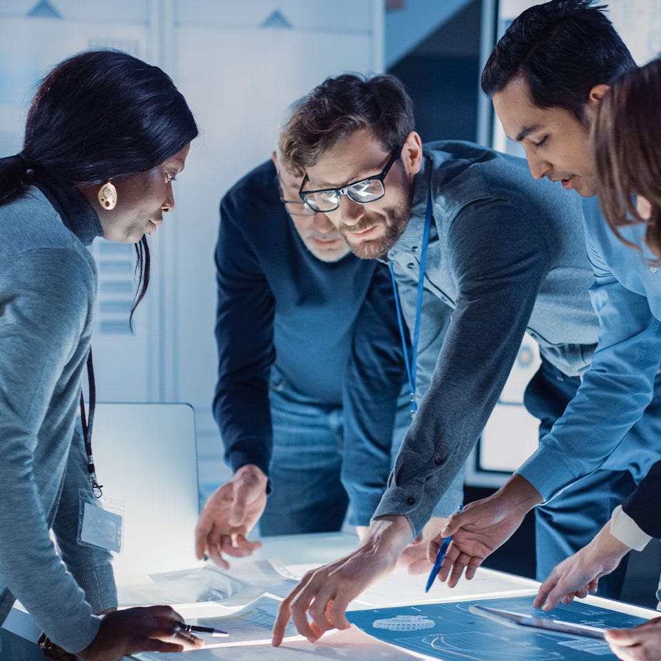 Developers Gathered Around Illuminated Conference Table, Talking and Finding Solution