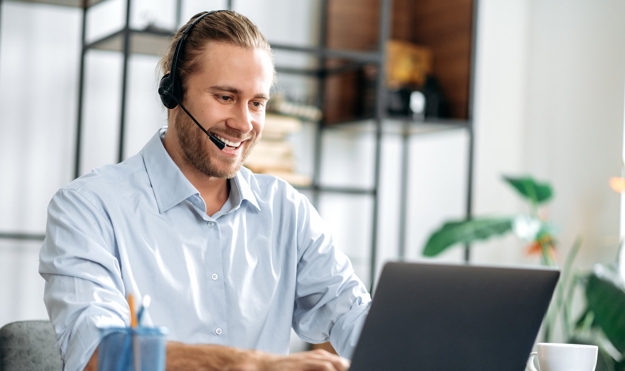 man talking on headset at laptop