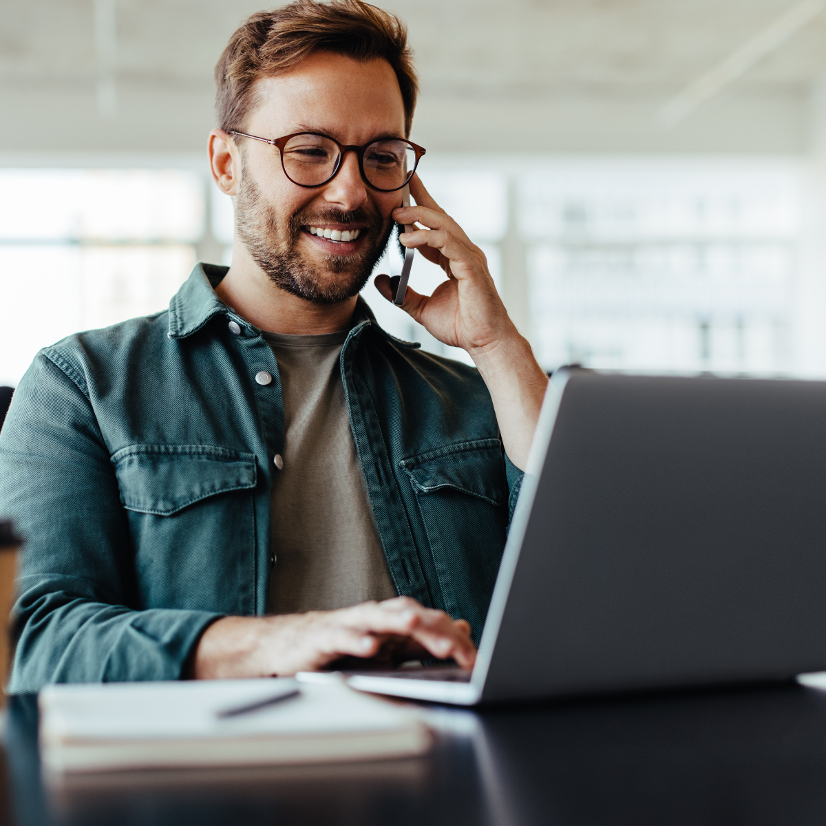man talking on phone with laptop